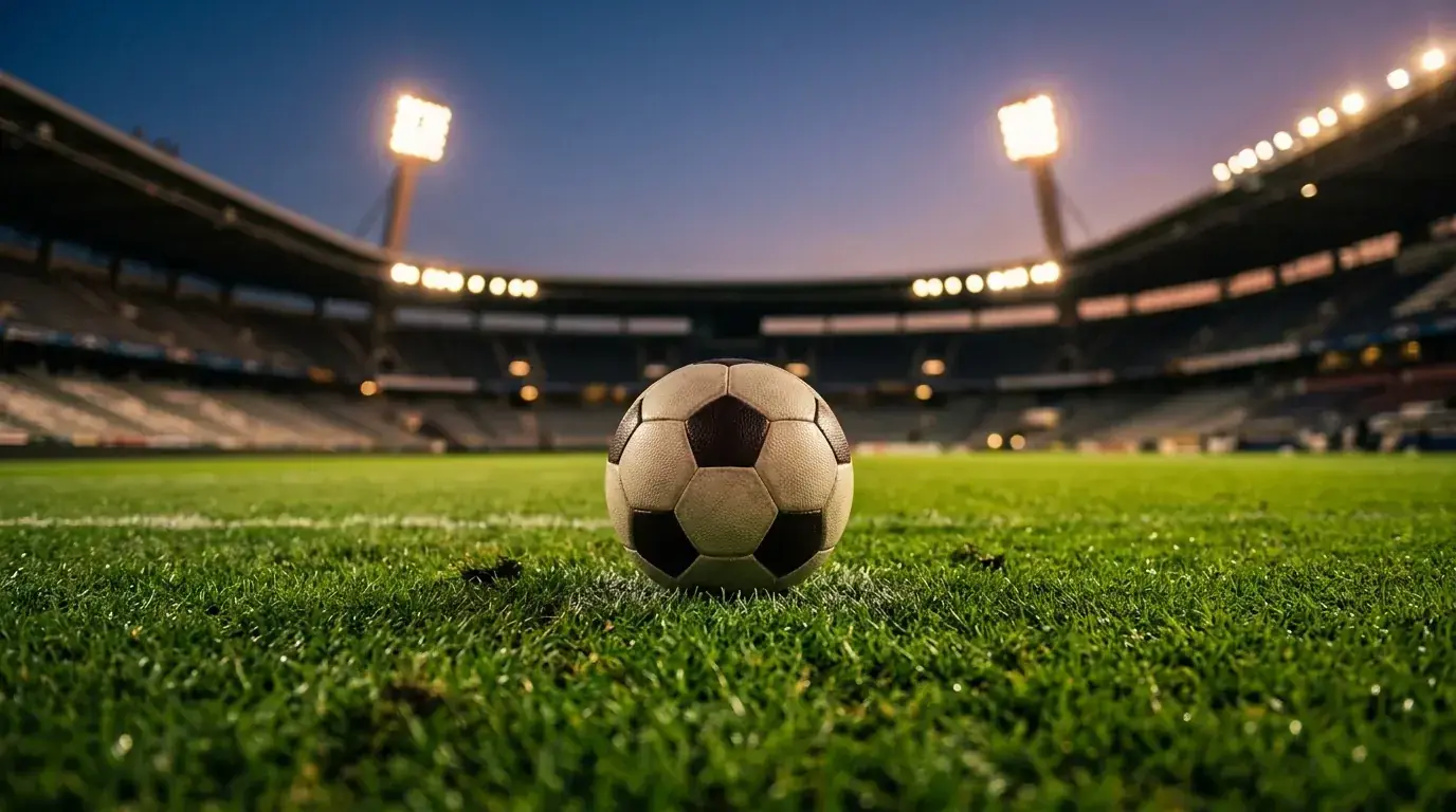 Balón de fútbol sobre el césped iluminado de un estadio antes de un partido nocturno del Mundial 2026